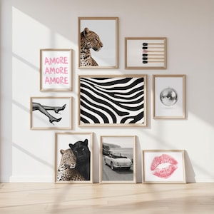 May include: A gallery wall arrangement of eight framed prints in light wood frames. The collection includes a leopard, matchsticks, the text AMORE AMORE AMORE in pink, legs in heels, black and white zebra stripes, a disco ball, a leopard and panther, a vintage car, and pink lips.