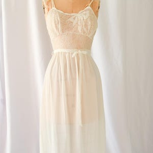 K&ouml;nnte beinhalten: Ein wei&szlig;es Nachthemd aus Spitze und Chiffon mit Schleife am Ausschnitt und einer Schleife in der Taille.