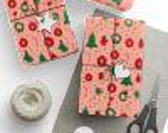May include: Two pink gift boxes wrapped in Christmas paper with a red, green, and white pattern. The boxes are tied with twine and have a white paper tag attached.