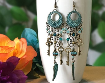 chandelier earrings - feather and key charms, bronze patina: blue green, beads in aqua, light blue, turquoise, antiqued bronze charms