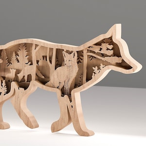 Puede incluir: Escultura de madera con forma de zorro y diseño en capas. La escultura presenta una detallada escena forestal dentro de su silueta, incluyendo árboles y otro zorro. El color natural de la madera resalta los intrincados detalles recortados.