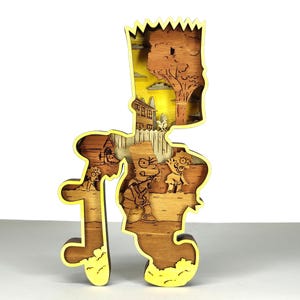 May include: A multi-layered wooden sculpture of Bart Simpson, with a yellow border and a detailed Springfield scene. The artwork depicts a sunset, a house, and characters from the show, all within the Bart silhouette.