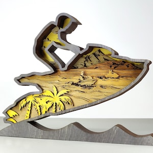 Pu&ograve; includere: Scultura in legno multistrato raffigurante una persona su una moto d'acqua. L'opera utilizza tonalit&agrave; gialle e marroni, con palme e altre moto d'acqua visibili. La base &egrave; grigia e a forma di onde. Alta circa 20 cm.