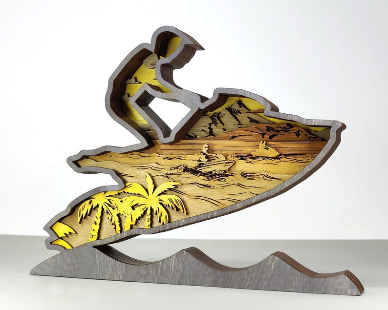 Pu&ograve; includere: Scultura in legno multistrato raffigurante una persona su una moto d'acqua. L'opera utilizza tonalit&agrave; gialle e marroni, con palme e altre moto d'acqua visibili. La base &egrave; grigia e a forma di onde. Alta circa 20 cm.