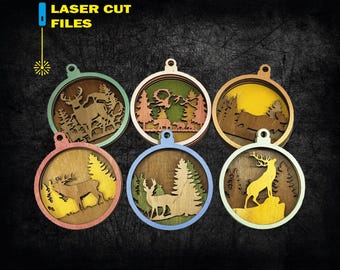 Pode incluir: Seis enfeites de madeira cortados a laser com cenas de veados e florestas. Cada enfeite circular tem uma borda e um design interior de cor diferente. O texto "LASER CUT FILES" está no canto superior esquerdo.