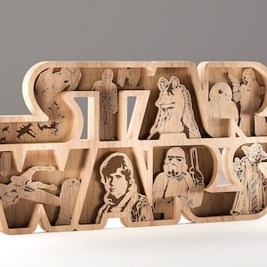 May include: Wooden Star Wars sign with laser-cut character and spacecraft images. The sign spells "STAR WARS", with compartments for Luke Skywalker, Yoda, and a Stormtrooper. The sign is made of light-coloured wood, and is a decorative item.