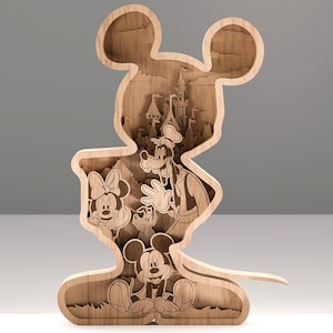 Op de afbeelding: Een houten gelaagd kunstwerk in de vorm van Mickey Mouse. De binnenkant toont iconische Disney-personages zoals Minnie Mouse, Goofy en Mickey Mouse, samen met een kasteel. Het stuk is gemaakt van lichtbruin hout.