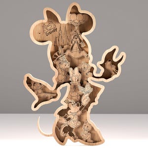 Può includere: Un'opera d'arte in legno a strati a forma di Minnie Mouse, con vari personaggi Disney. L'opera è realizzata in legno marrone chiaro e include personaggi come Topolino, Paperino e Pippo. La parola "Disney" è visibile nel design.