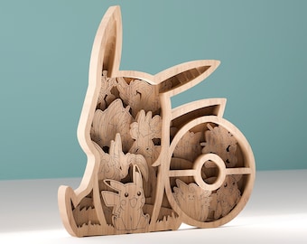 May include: A wooden, multi-layered sculpture featuring various Pokémon characters. The sculpture is in the shape of the Pokémon logo. The characters are intricately carved and visible within the layers. The sculpture is made of light-colored wood.