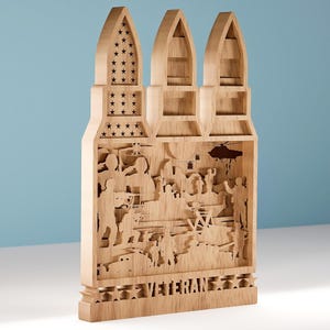 May include: A wooden decorative shelf in the shape of three bullets. The shelf features a detailed relief carving of soldiers and a helicopter. The word "VETERAN" is carved at the base, and stars are cut into the top of the bullets.