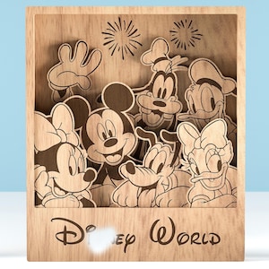 Könnte beinhalten: Disney World Holzschild mit Mickey Mouse, Minnie Mouse, Goofy, Donald Duck, Daisy Duck und Pluto. Die Charaktere sind in einem geschichteten Design mit Feuerwerk darüber gelasert. Das Schild befindet sich in einem Holzrahmen.