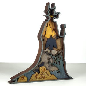 Puede incluir: Escultura de madera en capas que representa una figura con sombrero y botella. La escultura presenta una combinaci&oacute;n de colores azul oscuro, marr&oacute;n y amarillo, con un p&aacute;jaro y elementos de paisaje. Una pieza decorativa &uacute;nica.