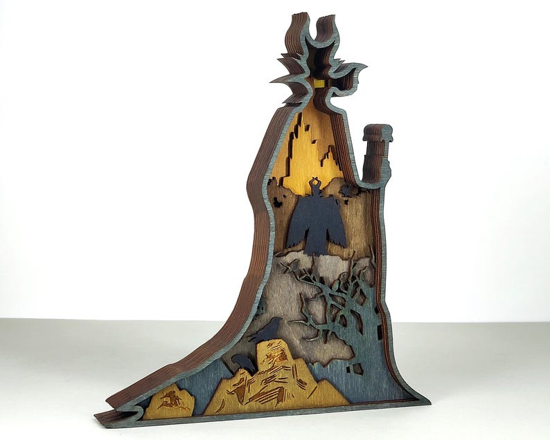 Puede incluir: Escultura de madera en capas que representa una figura con sombrero y botella. La escultura presenta una combinaci&oacute;n de colores azul oscuro, marr&oacute;n y amarillo, con un p&aacute;jaro y elementos de paisaje. Una pieza decorativa &uacute;nica.