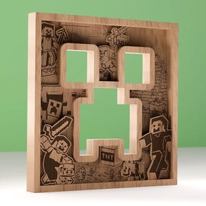 Puede incluir: Obra de arte enmarcada en madera con un diseño de Creeper de Minecraft. La obra de arte está hecha de madera en capas, con la cara del Creeper recortada. El marco es de color marrón claro y el fondo es verde.