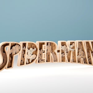 Può includere: Cartello in legno "SPIDER-MAN" con figure di supereroi intagliate all'interno di ogni lettera. Le lettere sono marroni chiare, con illustrazioni dettagliate di Spider-Man. Il cartello è esposto su una superficie bianca su sfondo azzurro chiaro.