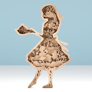 Puede incluir: Obra de arte de madera en capas que representa la silueta de una niña sosteniendo una bandeja, con intrincados recortes de escenas de Alicia en el país de las maravillas. El diseño incluye el Gato de Cheshire, setas y otros elementos caprichosos. La pieza está hecha de madera clara.