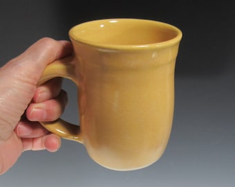 Taza de café o té de cerámica amarilla.