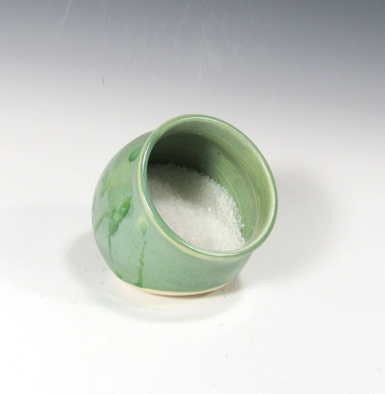 Photo shows a pottery salt pig or salt cellar. It has an opening on its side that is 3 inches wide. There is salt in the container.
