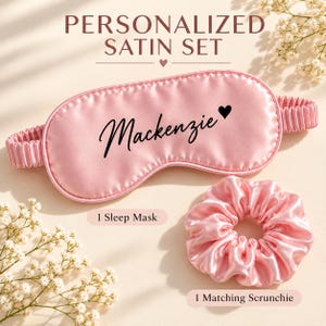 May include: A personalized satin sleep set featuring a light pink sleep mask with the name Mackenzie and a small heart printed in black, accompanied by a matching pink satin scrunchie. The text Personalized Satin Set is visible above.