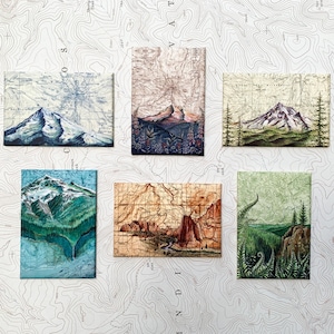 May include: Six vintage-style illustrated postcards featuring different mountain landscapes. Each postcard has a map-like background with a mountain scene in the center. The postcards are arranged in two rows of three.