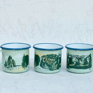 May include: Three enamel mugs with a green and yellow design featuring the text "Olympic National Park".