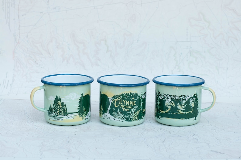 May include: Three enamel mugs with a green and yellow design featuring the text "Olympic National Park".