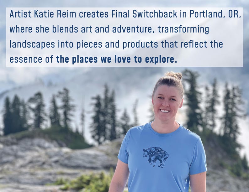 May include: A woman wearing a light blue t-shirt with a bison graphic, standing in front of a mountain landscape. The text above reads: "Artist Katie Reim creates Final Switchback in Portland, OR, where she blends art and adventure, transforming landscapes into pieces and products that reflect the essence of the places we love to explore."