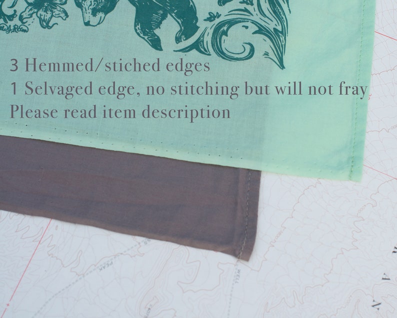 May include: A light green fabric square with a dark green floral design and a bear illustration. The fabric has 3 hemmed/stitched edges and 1 selvaged edge. The text "3 Hemmed/stitched edges 1 Selvaged edge, no stitching but will not fray, Please read item description" is printed on the fabric.