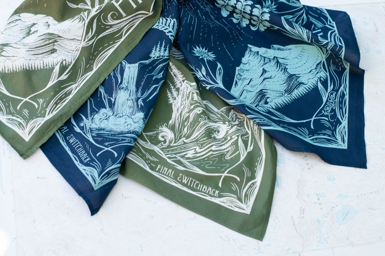 May include: Three green and blue bandanas with white illustrations of mountains, trees, and water. The bandanas have the text "Final Switchback" printed on them.