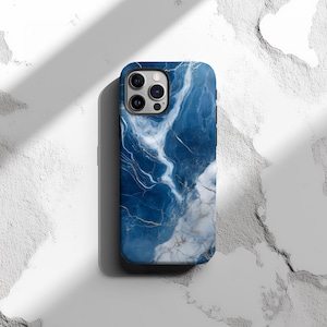 May include: A blue and white marble phone case with a camera cutout. The case has a swirling pattern of blue and white.