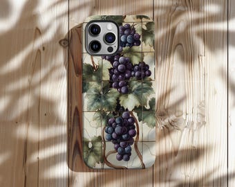 May include: A smartphone case featuring a detailed illustration of purple grapes and green leaves on a vine. The design is set against a cream-colored, tiled background. The case is on a wooden surface.