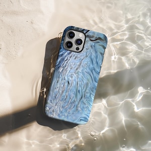 May include: A smartphone case with a blue and white abstract water design. The case has a glossy finish and a black border. The phone case is lying in shallow water, creating a reflective effect.