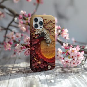 May include: A phone case with a colorful floral design featuring a wave and a mountain landscape. The case has a camera cutout and a textured surface.