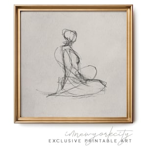 Può includere: Un'opera d'arte da parete quadrata incorniciata che presenta un disegno a linee nere in stile carboncino di una figura seduta su uno sfondo grigio chiaro. L'opera è racchiusa in una cornice dorata metallizzata. Sotto la cornice, il testo recita innewyorkcity EXCLUSIVE PRINTABLE ART.