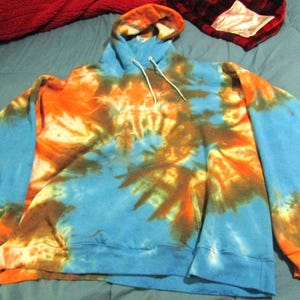 May include: A blue, orange, and brown tie-dye hoodie with a white drawstring.