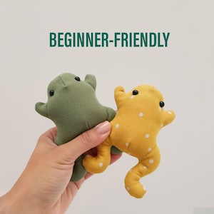 Peut inclure: Deux peluches en forme de grenouille faites &agrave; la main. L'une est vert olive, l'autre est jaune &agrave; pois blancs. Les deux ont des yeux noirs en forme de bouton. Le texte "BEGINNER-FRIENDLY" est au-dessus des grenouilles.