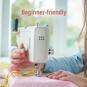Peut inclure: Une machine &agrave; coudre blanche avec une bobine de fil noire est en cours d'utilisation. Elle coud un tissu rose &agrave; pois blancs. Un m&egrave;tre ruban jaune et du fil rose sont &eacute;galement visibles. Le texte "Beginner-friendly" est affich&eacute;.