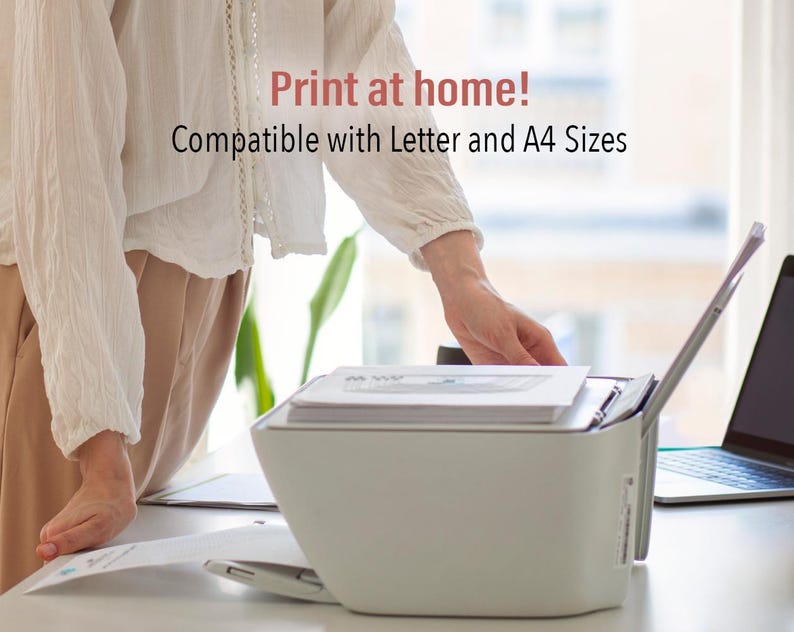 May include: A white printer with a document tray and a paper feed slot. The printer is on a white desk with a laptop computer to the right. The text "Print at home! Compatible with Letter and A4 Sizes" is displayed above the printer.