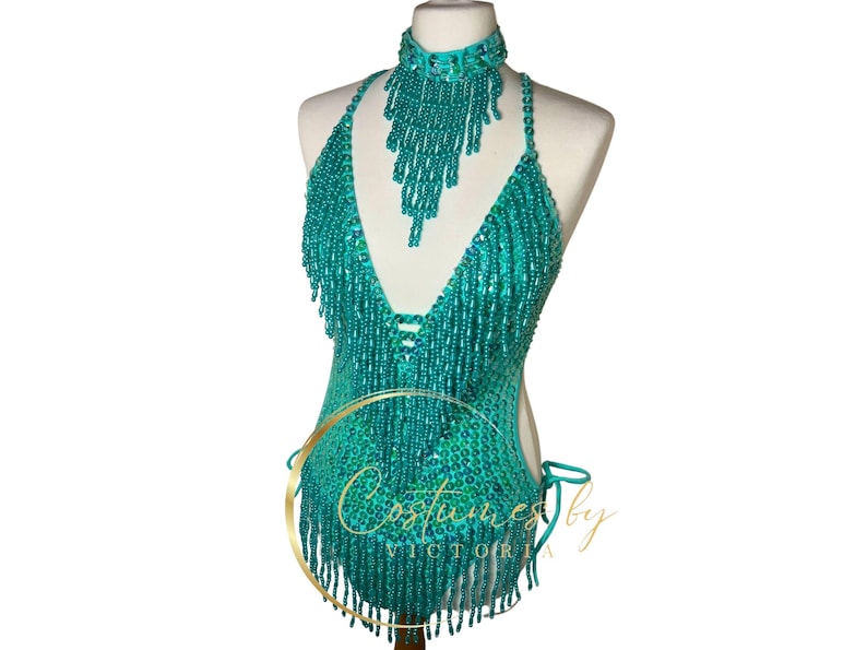 May include: A turquoise beaded halter top with fringe and a matching beaded choker. The top has a deep V-neckline and is made of sequins and beads.