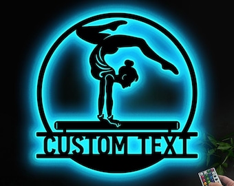 Puede incluir: Un letrero de neón azul con la silueta de una gimnasta realizando un salto mortal hacia atrás en una viga de equilibrio. El letrero tiene el texto "CUSTOM TEXT" debajo de la gimnasta.