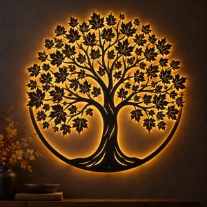 May include: A circular wall art piece featuring a black metal silhouette of a tree with detailed maple leaves. The design is enclosed within a circular frame and is illuminated from behind by a warm, glowing light that highlights the tree shape.