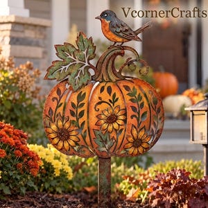 May include: A metal garden stake featuring a cutout pumpkin design with orange and green patina finishes. The pumpkin is decorated with sunflower motifs and topped with a small bird figure. The text VcornerCrafts appears in the upper right corner.