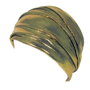 May include: A gold metallic turban style head wrap. The fabric is shiny and has a slight crinkle texture.