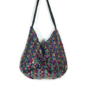May include: A rainbow sequined hobo bag with a black shoulder strap.