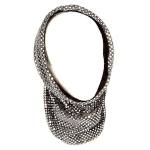 Può includere: Un foulard per la testa nero e scintillante con strass. Il foulard è realizzato in un materiale elastico ed è progettato per essere indossato come un copricapo.