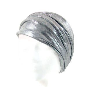 May include: A silver turban headband with a shiny, metallic finish. The headband is made of a soft, stretchy fabric and is designed to be worn comfortably.