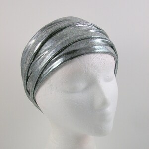 May include: A silver metallic headband with a crinkled texture. The headband is worn on a white mannequin head.