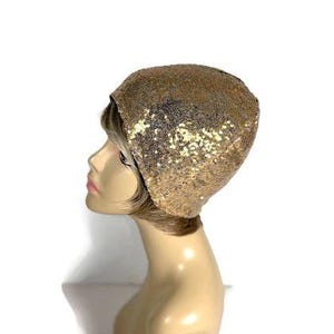 May include: A gold sequined beanie hat. The hat is made of a soft, stretchy fabric and is perfect for adding a touch of sparkle to any outfit.