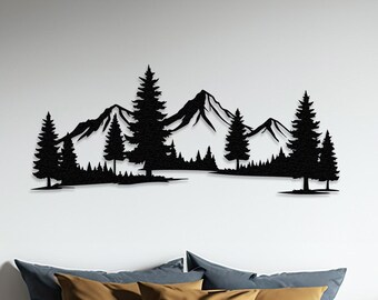 May include: Black metal wall art depicting a mountain range with pine trees in front. The art is mounted on a white wall above a bed with a gray and brown blanket.