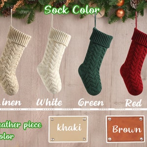 Op de afbeelding: Vier gebreide kerstsokken in de kleuren linnen, wit, groen en rood. De sokken hangen aan een houten muur met een bord waarop "Sokkleur" staat. Onder de sokken bevinden zich drie lederen stukken in de kleuren kaki, bruin en bruin.